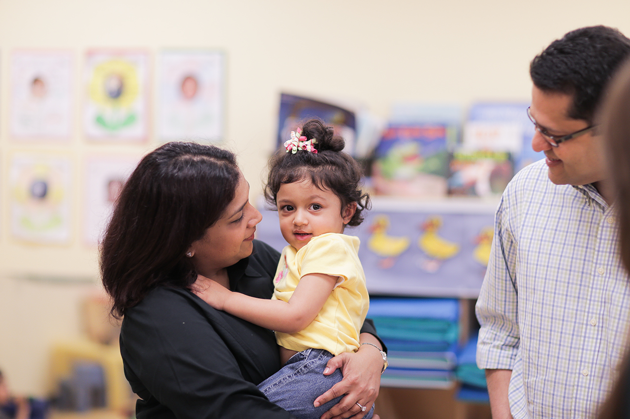 A mother holds her child in a Goddard School classroom